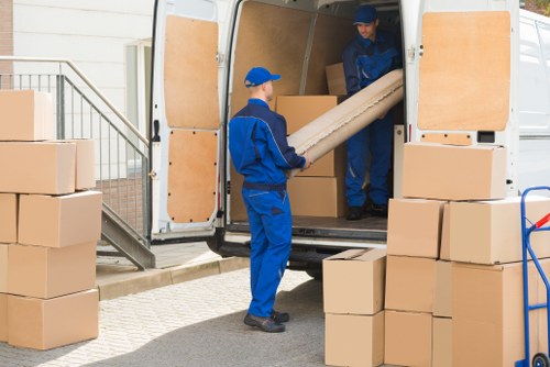 Moving van and packed boxes in a Chelsea street setting